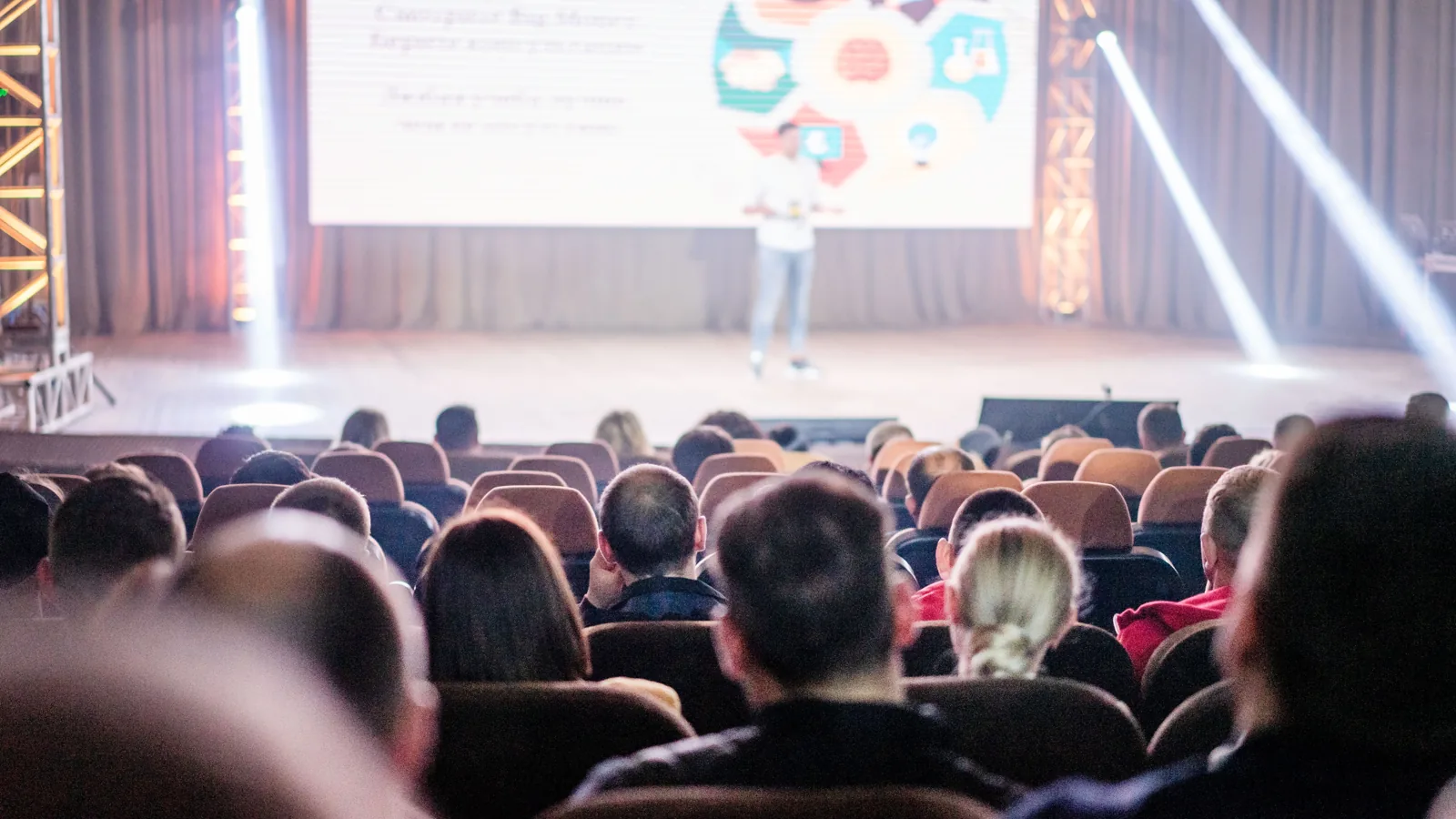 Konferenzbühne mit Rednerpult, Leinwand und dezenter Beschallung